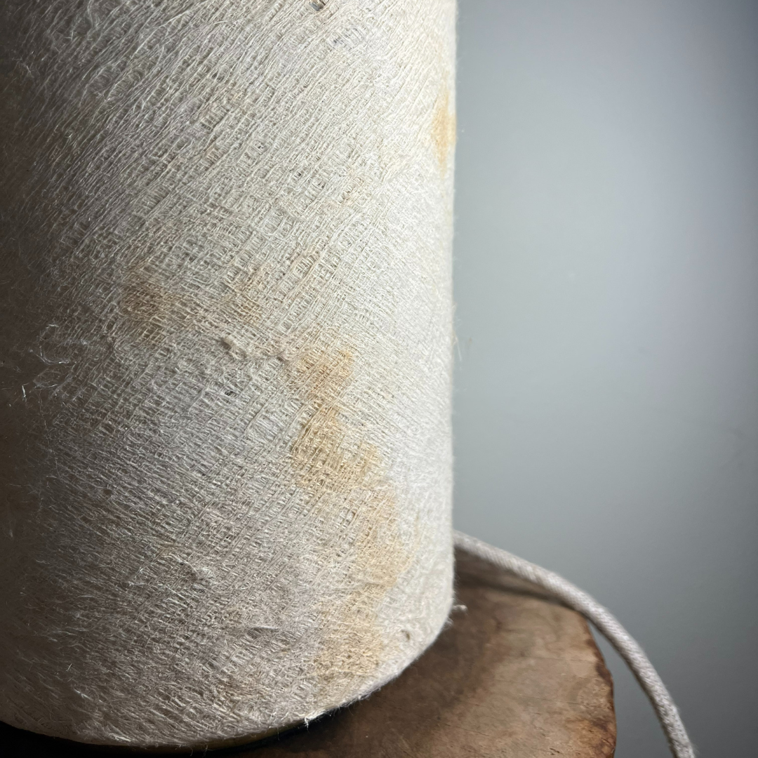 Lampe de chevet en écorce d'arbre blanche posée sur une table de chevet en bois