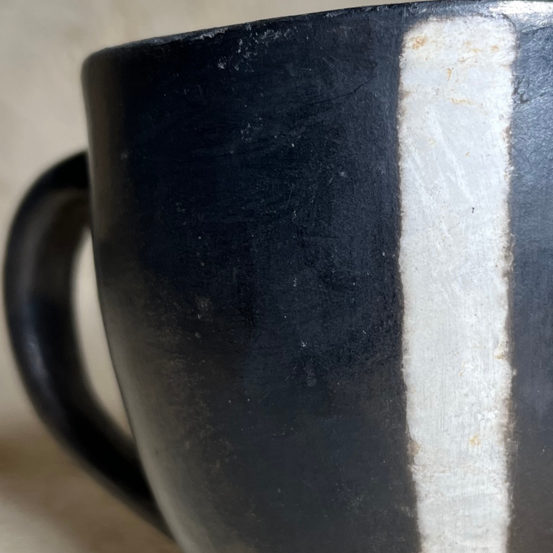 Gros plan sur une tasse en terre cuite noire et blanche
