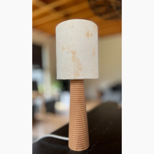 Lampe de table en écorce d'arbre blanche et pied en bois tourné, dans un intérieur cosy
